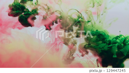 Underwater smoke. Floating paint. Colorful drop haze green pink liquid dissolve pigment. Art chemical splash abstract blur background. 129447245
