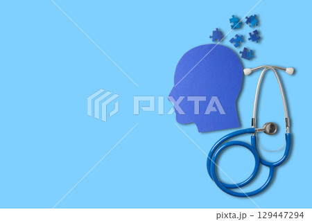 Stethoscope near a head silhouette filled with puzzles 129447294