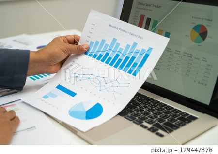 Asian business woman working with financial graph. 129447376