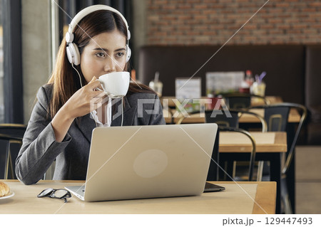 Women helpdesk call center use headphones talk to customer. Asian woman operator assistant customer service relationship agent. Businesswoman use laptop computer video call online meeting. 129447493