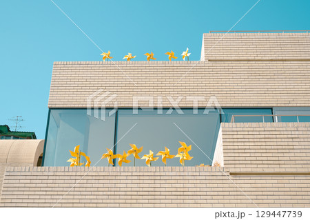 Yellow pinwheel and building. minimalism architecture Yellow pinwheel and building. minimalism architecture 129447739
