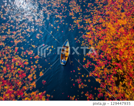 秋の湖に浮かぶ小舟と紅葉の絶景空撮 129447935
