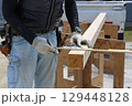 大工さんが丸ノコ用角度切り定規を使っている 129448128