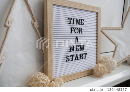 TIME FOR A NEW START text on black letter board with cozy minimalistic handmade Christmas decor. New year aims resolutions. Low key festive Planning and setting goals 129448357