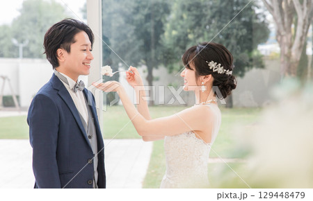 結婚式でファーストバイトをする新郎新婦(ウェディングケーキ・ケーキ入刀) 129448479