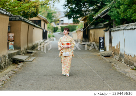 武家屋敷群を散策する着物姿の女性 129449636
