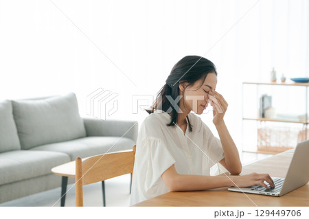 パソコンの前で頭を抱える若い女性 パソコンの前で頭を抱える若い女性 129449706