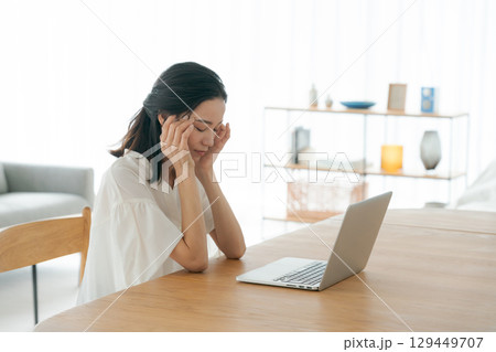 パソコンの前で頭を抱える若い女性 129449707