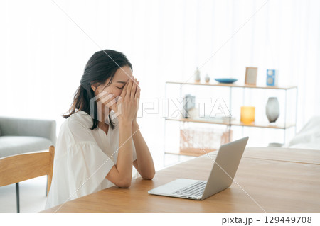 パソコンの前で頭を抱える若い女性 129449708