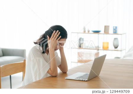パソコンの前で頭を抱える若い女性 129449709