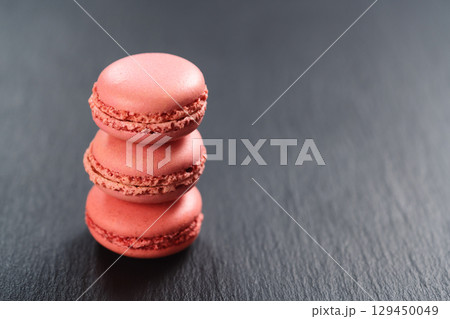 Strawberry macarons stacked on slate board with copy space 129450049