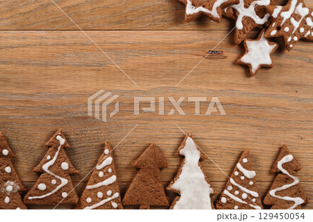 Gingerbread chrismas cookies on oak wood background with copy space Gingerbread chrismas cookies on oak wood background with copy space 129450054