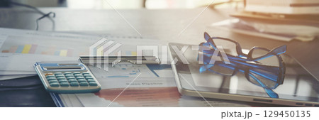 Banner Top view office desk laptop and coffee cup on wood table copy space.  Panorama tabletop notebook laptop coffee cup for officer display empty space wooden background workspace full banner design 129450135
