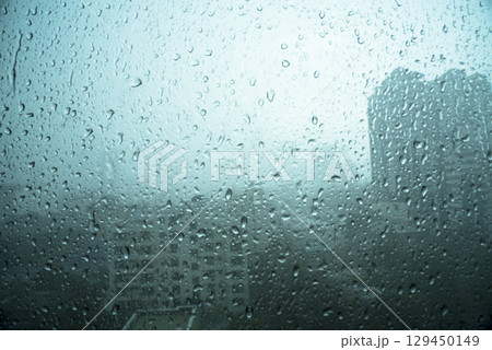 Raindrop on window blue background aqua bubble texture. Rainy water surface splash glass. Blurred background falling rain shower windy outdoors. Motion macro raindrops splash pattern design element Raindrop on window blue background aqua bubble texture. Rainy water surface splash glass. Blurred background falling rain shower windy outdoors. Motion macro raindrops splash pattern design element 129450149