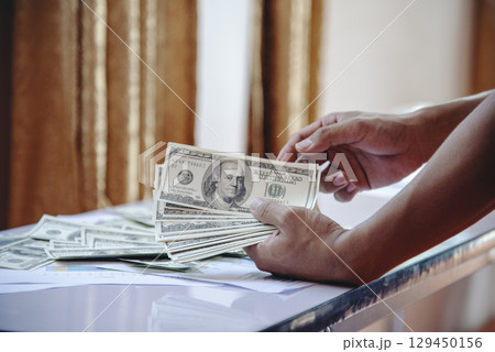 Hand holding loan money dollar bank note give financial payment. Man hands showing spread 100 dollar exchange cash payout. Saving Businessman counting money banknote  bribe corruption concept. 129450156