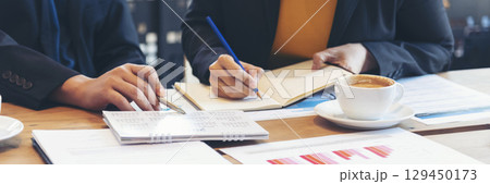 Banner Two businesspeople meeting work at office desk. Teamwork partners team with Business strategy chart graph, infographic financial report. Team partner planning excel stat report with copy space 129450173