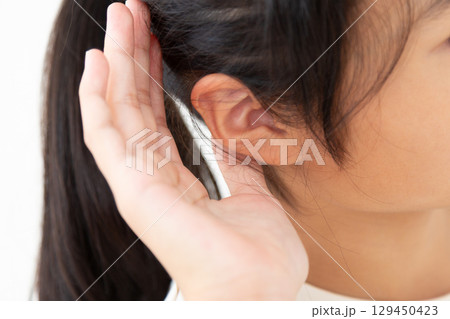 耳をすませる中学生の女の子 129450423