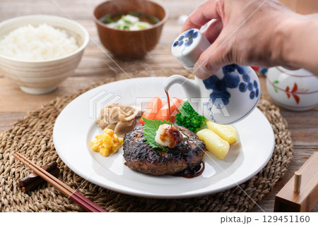 湯気立つ和風おろしハンバーグと彩り野菜の定食　温かい家庭料理やレストランメニューに最適 129451160