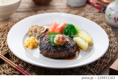 湯気立つ和風おろしハンバーグと彩り野菜の定食　温かい家庭料理やレストランメニューに最適 129451163
