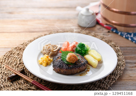 湯気立つ和風おろしハンバーグと彩り野菜の定食　温かい家庭料理やレストランメニューに最適 129451168