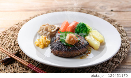 湯気立つ和風おろしハンバーグと彩り野菜の定食　温かい家庭料理やレストランメニューに最適 129451170