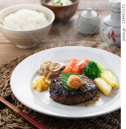 湯気立つ和風おろしハンバーグと彩り野菜の定食　温かい家庭料理やレストランメニューに最適 129451172