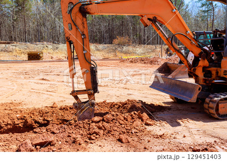 Excavator operates at construction site surrounded by construction site efficiently digs trench ground under works day 129451403