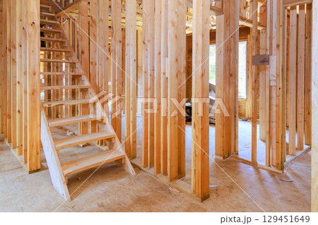 Wooden framing in residential construction site reveals staircase an open layout ready for further development. 129451649