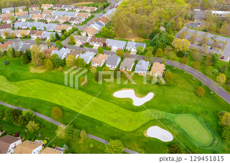 Residential neighborhood landscape showing houses along curved roads with mature trees well maintained spaces in Middlesex County, New Jersey. 129451815