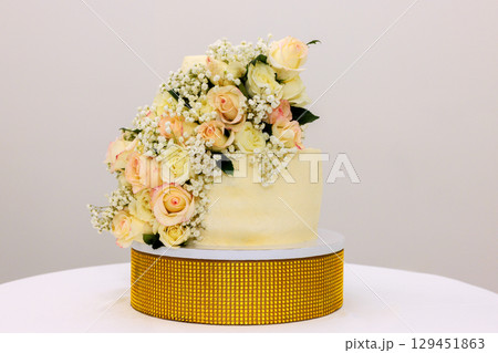 Beautifully decorated wedding cake features fresh roses blooms, enhancing its elegance for special event. 129451863