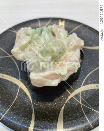 An assortment of fresh sushi, artfully arranged with a variety of toppings and vibrant colors. This traditional Japanese dish combines vinegared rice, seafood, and vegetables for an experience. 129451974