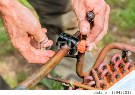 HVAC technician cutcopper tubing valves on refrigeration system HVAC technician cutcopper tubing valves on refrigeration system 129452032