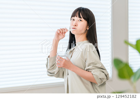 家で歯ブラシを使って歯磨きをする若い若いアジア人,日本人女性(デンタルケア) 129452182