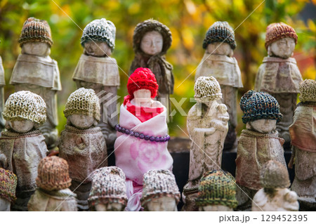 Jizu statue in red knit hat and necklace bead at Hasedera temple, Nara 129452395