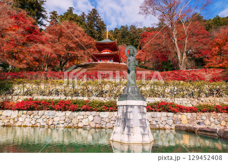 Guanyin statue at pond by autumn garden and Katsuoji pagoda, Osaka 129452408