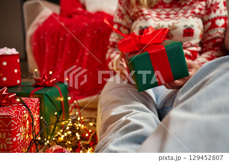 Woman holding Christmas gift near and presents 129452807