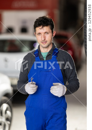 Service station man employee works in repair box, department Service station man employee works in repair box, department 129452938