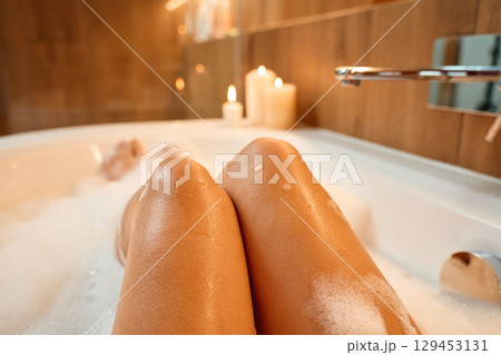 Woman relaxing in bathtub with foam Woman relaxing in bathtub with foam 129453131