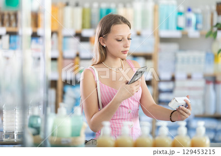 Girl in summer clothes scans code on package of pills to check expiration date Girl in summer clothes scans code on package of pills to check expiration date 129453215