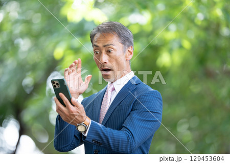 ビジネスマン 新緑 スマホ 驚く ビジネスマン 新緑 スマホ 驚く 129453604
