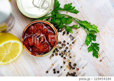 Image of pickled squids in American Salsa sauce in open tin can 129454184