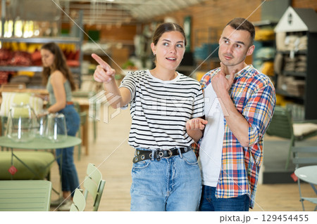 Friendly couple looking for comfortable furniture in garden store 129454455