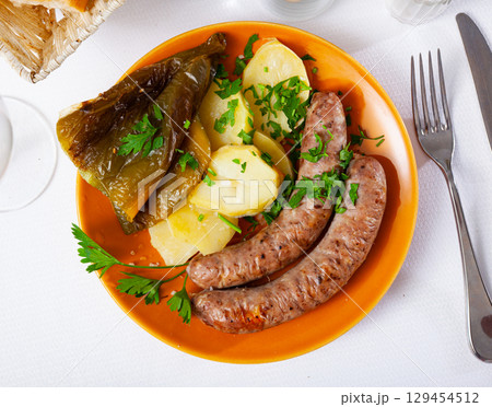 Delicious sausages and boiled potatoes with stewed peppers 129454512