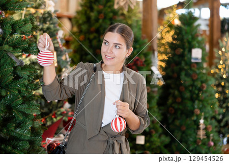 Woman purchasing decorations at christmas fair shop Woman purchasing decorations at christmas fair shop 129454526