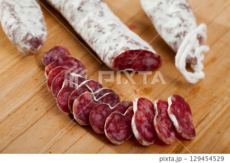 Slicing delicious Spanish smoked sausage fuete Slicing delicious Spanish smoked sausage fuete 129454529