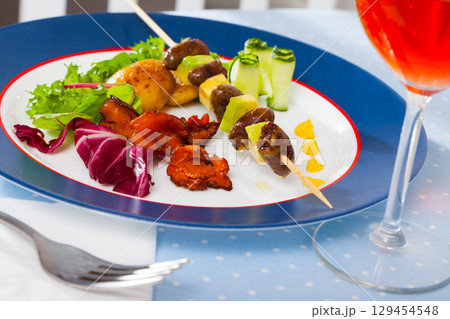 Fried chicken heart skewers with avocado and fried chanterelles served at plate Fried chicken heart skewers with avocado and fried chanterelles served at plate 129454548