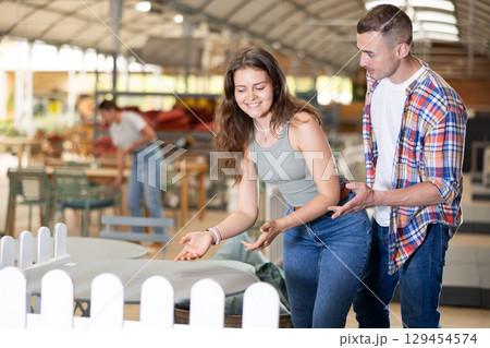 Spouses buyer choose table desk in garden furniture store showroom 129454574
