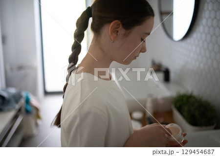 Teenager treating acne, taking care of her skin at home. Teenager treating acne, taking care of her skin at home. 129454687