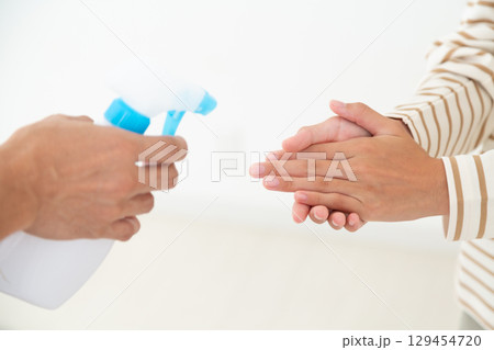 手のアルコール消毒をする中学生の女の子 129454720