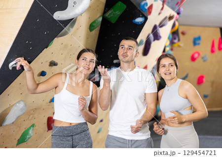 Young women and man - group of friends stand actively relaxing in climb hall 129454721